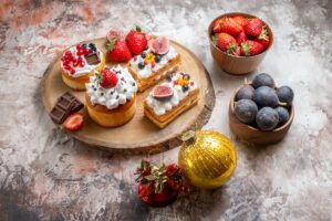 front-view-delicious-cakes-with-fresh-fruits-light-background-christmas-cake-dessert-color-biscuits (1)