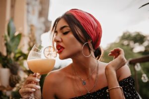 attractive-brunette-haired-girl-with-pink-headband-round-silver-earrings-bright-bandana-black-shirt-drinking-cocktail (1)